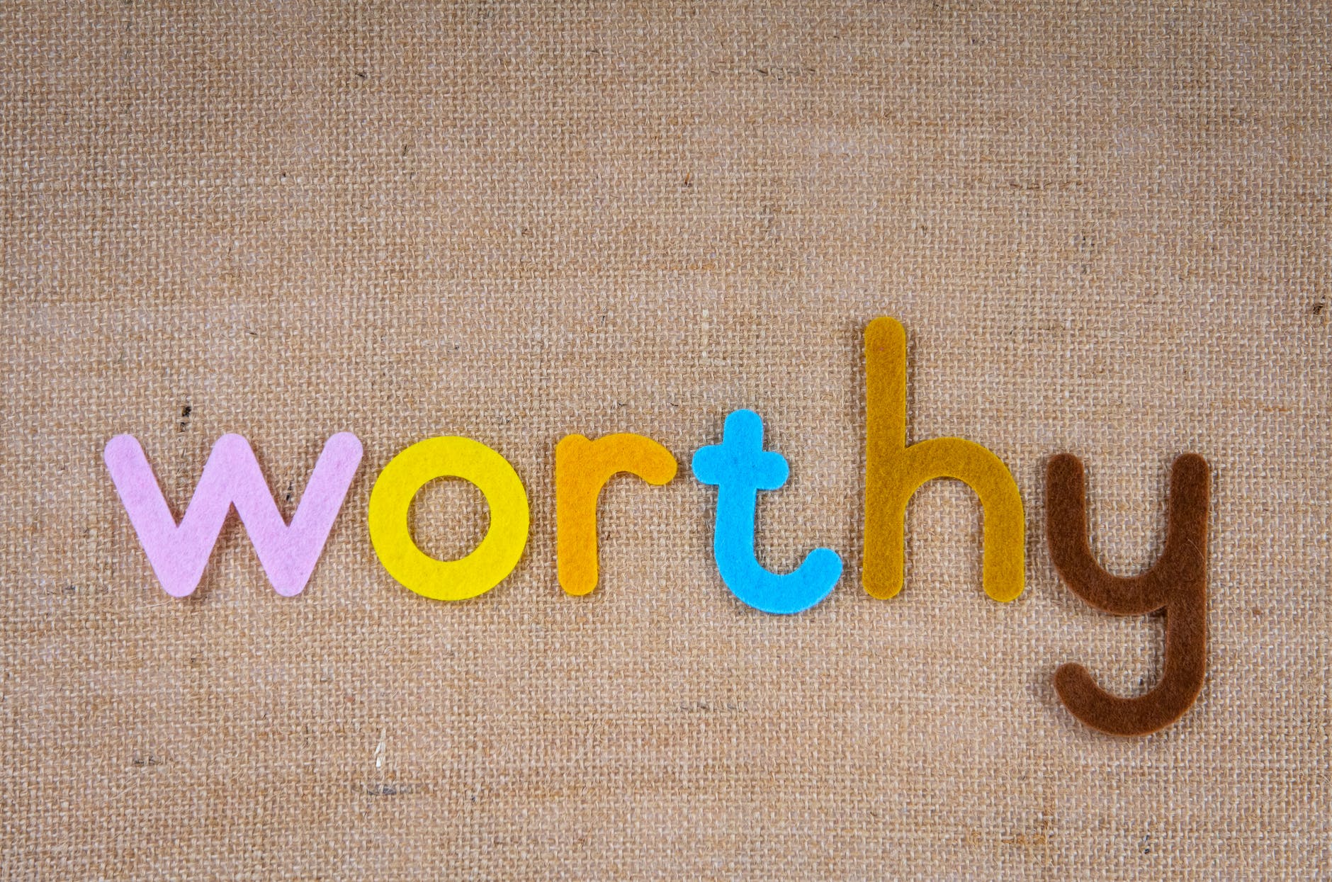 the word worthy on a woven surface