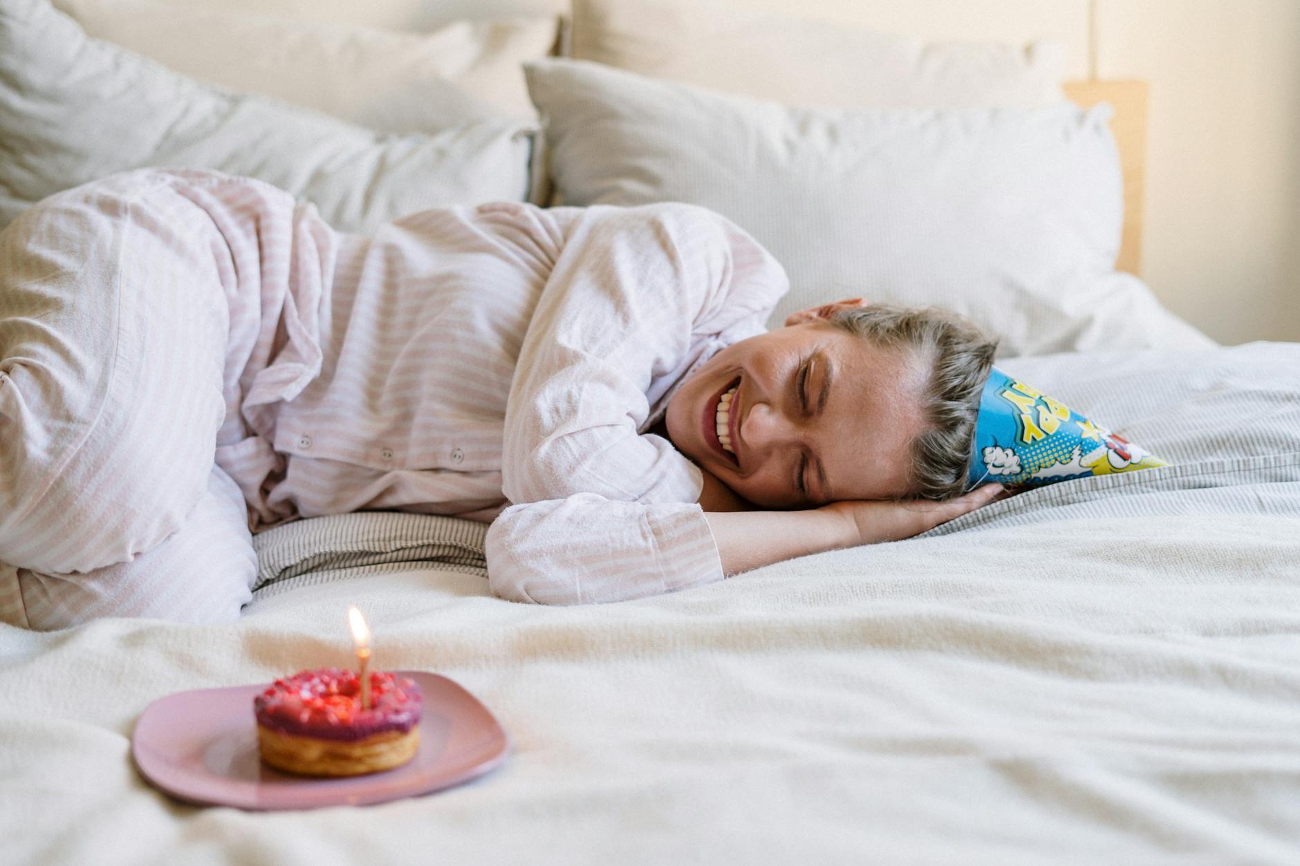 woman in white sweater lying on bed