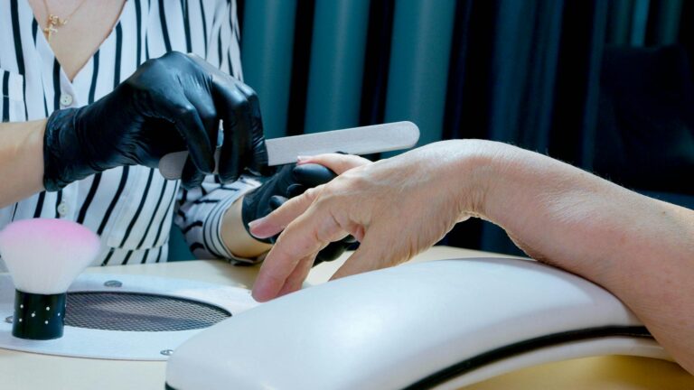 manicurist filing the nails of a client