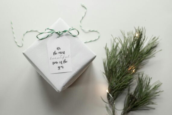 composition of gift box with coniferous branches on table