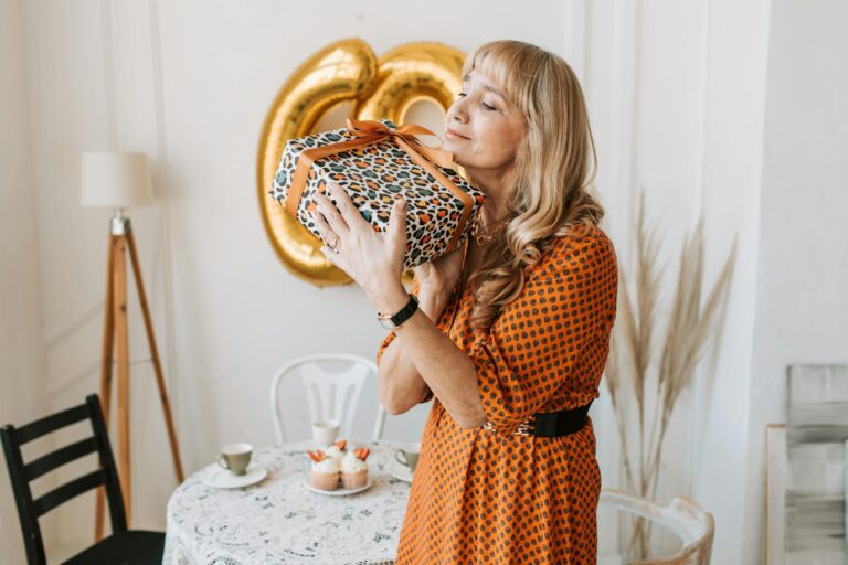 woman in black and orange dress holding a gift