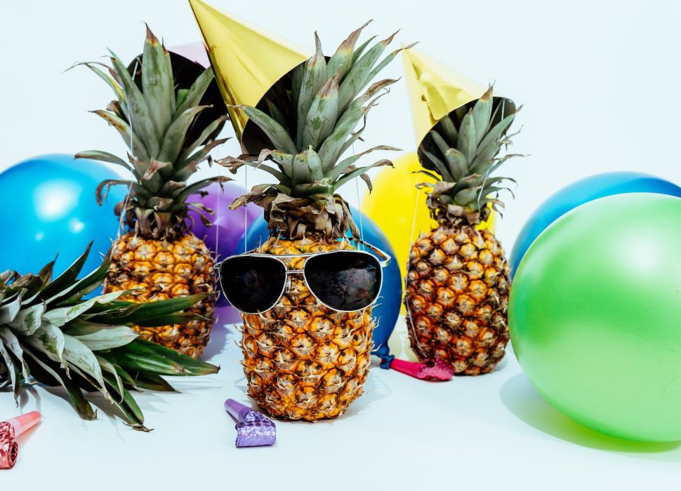 photo of three pineapples surrounded by balloons