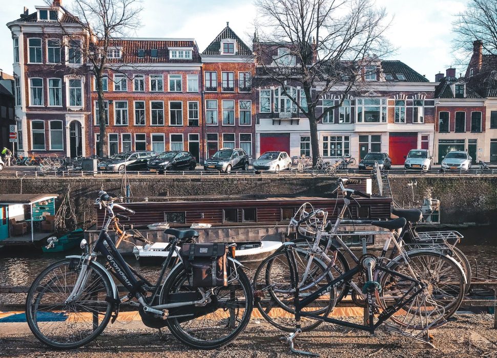 bicycles parked beside brown wooden fence near a river