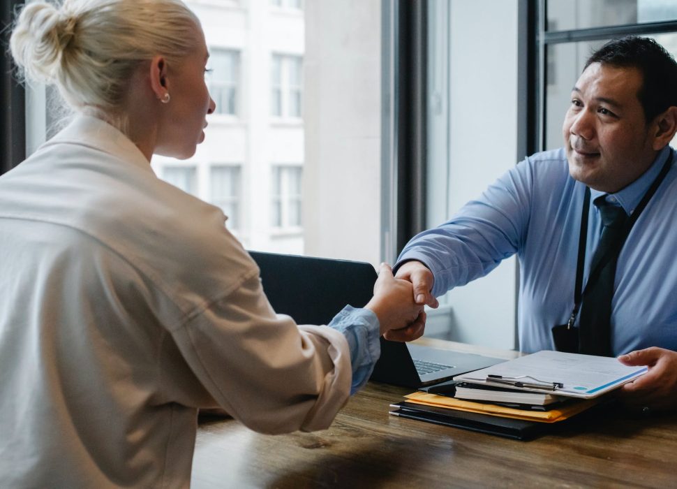 ethnic businessman shaking hand of applicant in office